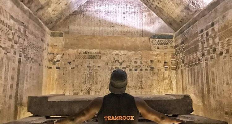 Une personne face à un mur peint vieux de plusieurs siècles.