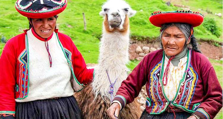 Vrouwen in traditionele kledij die staan met een lama.