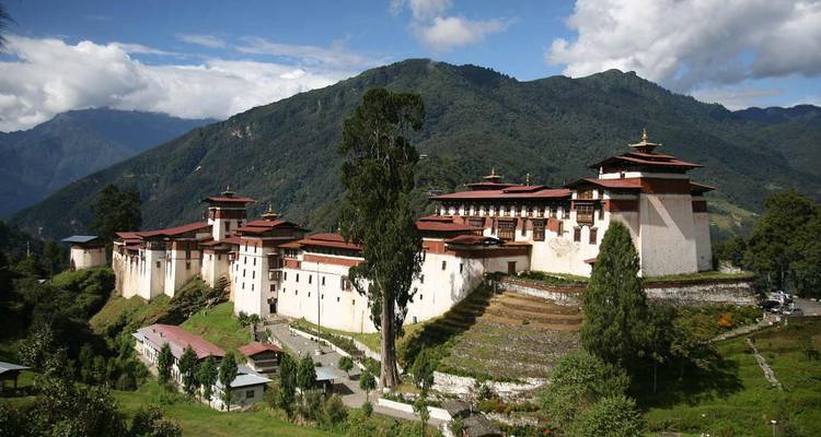 Weitläufiges Kloster auf einem Hügel mit Bergkulisse im Hintergrund.