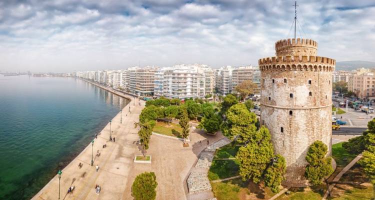 Vue panoramique d'un littoral urbain avec une tour et des espaces verts.