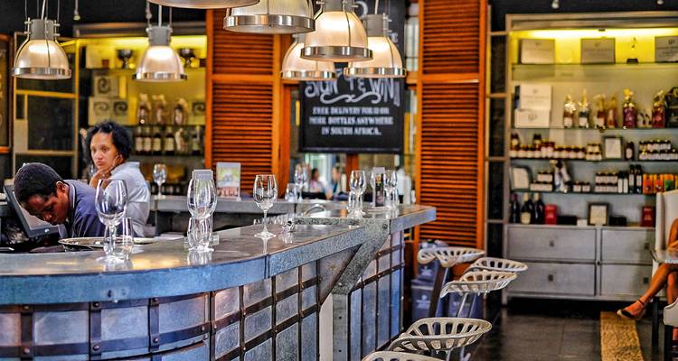 Interieur van een moderne bar met wijnglazen en gasten.