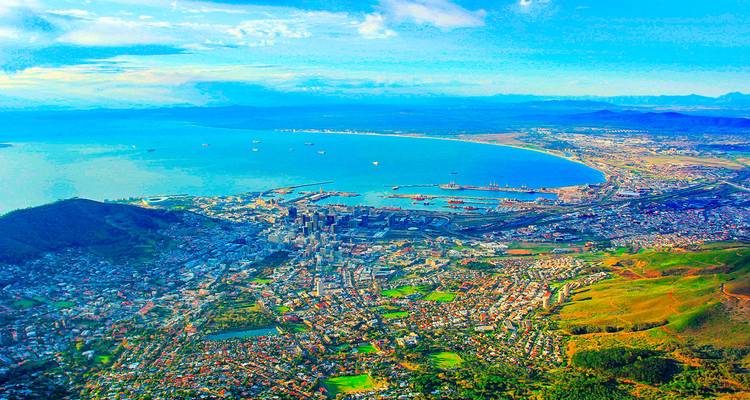 Luchtfoto van een kuststad met stranden en bergen.