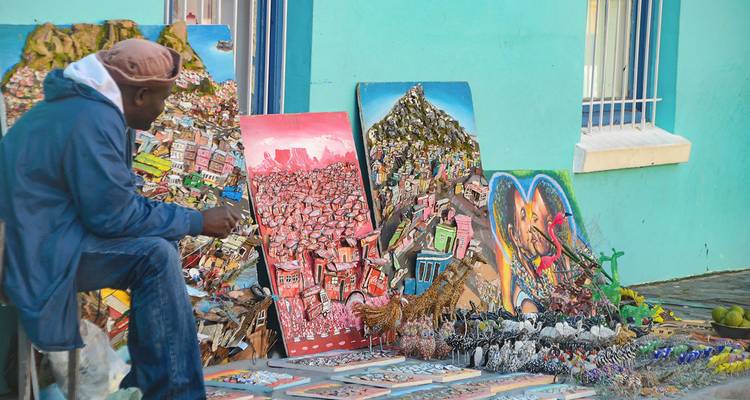 Straatverkoper die kleurrijke kunstwerken toont.