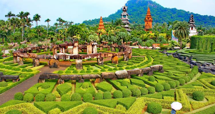 Kleurrijke tuin met topiary en stenen structuren.