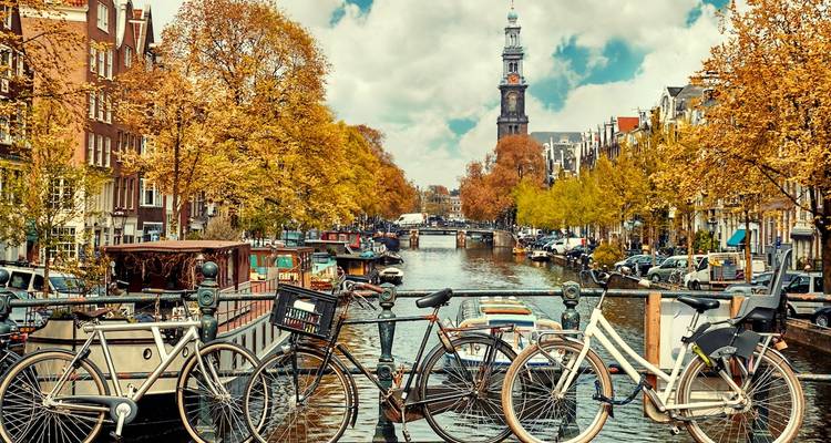 Amsterdam canal with bicycles and autumn trees.