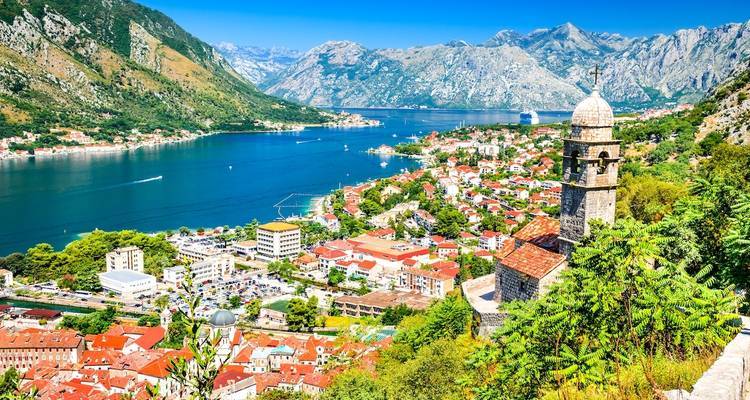 Scenic view of a coastal town with mountains and a bay.