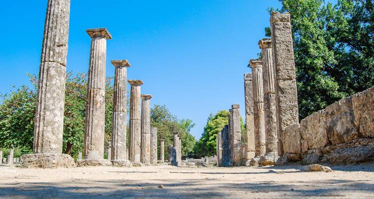 Ancient ruins with columns surrounded by trees in Olympia