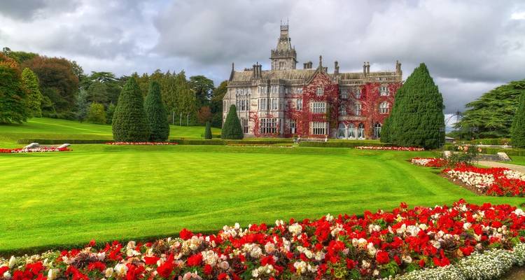 Historic manor house surrounded by meticulously manicured gardens.
