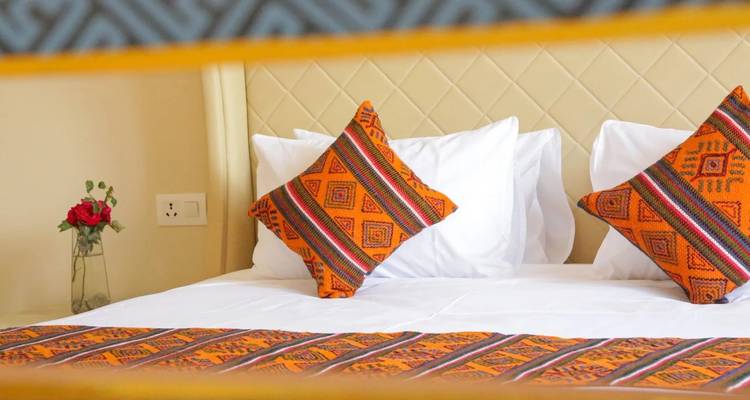 Interior of a luxurious hotel room with patterned pillows and decorations.