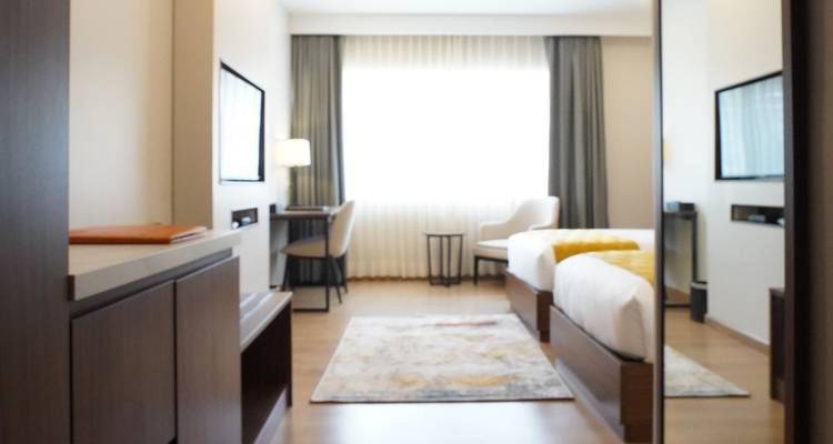 A blurred image of a hotel room with a window view.