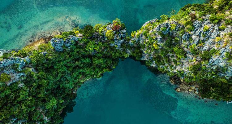 Aerial view of dramatic rocky islets in clear blue waters.