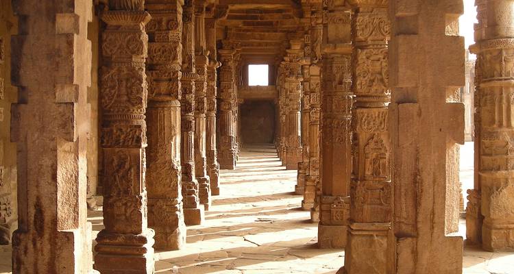 Ancient stone pillars with intricate carvings, leading to a doorway.