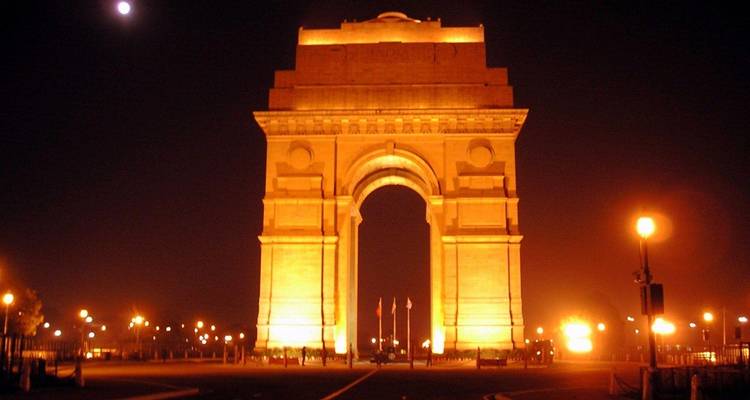 Illuminated arch monument at night.