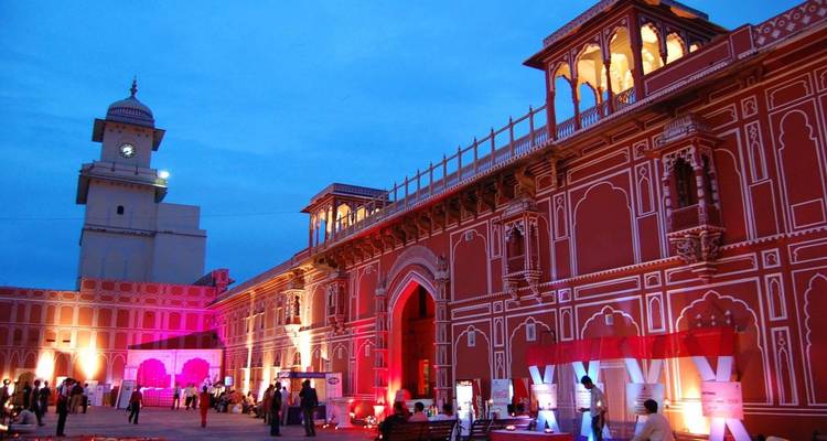 Illuminated grand building with cultural decorations and visitors.