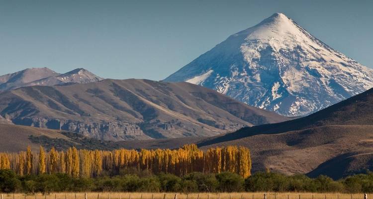 Een prominente met sneeuw bedekte berg staat tegen een heldere hemel.