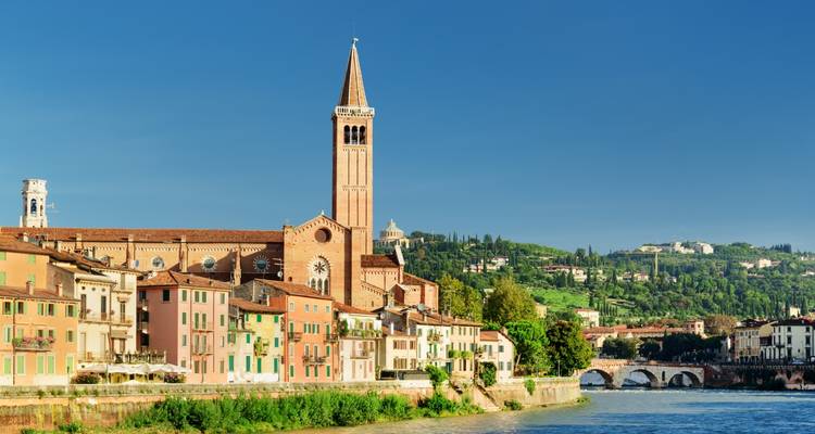 Het uitzicht op de rivier van Verona met de majestueuze klokkentoren van een kerk.