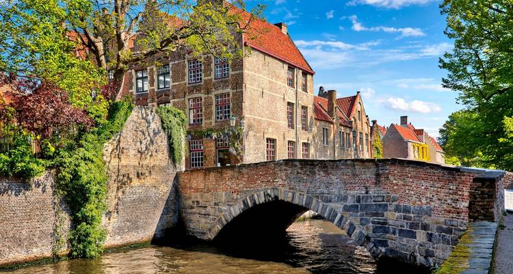 Brick bridge over a canal with historic buildings.