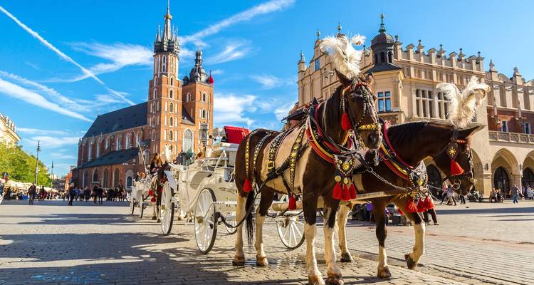 City square with horse carriages and historic church.