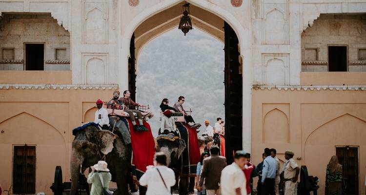 People riding elephants through a historic gate.