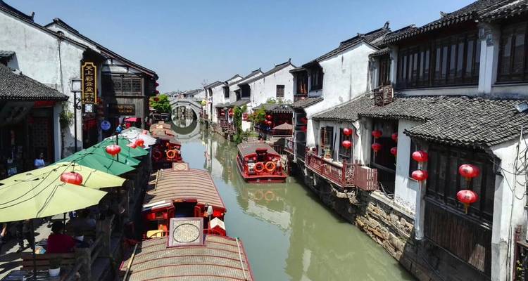 Canal traditionnel avec des bateaux et une architecture chinoise historique.