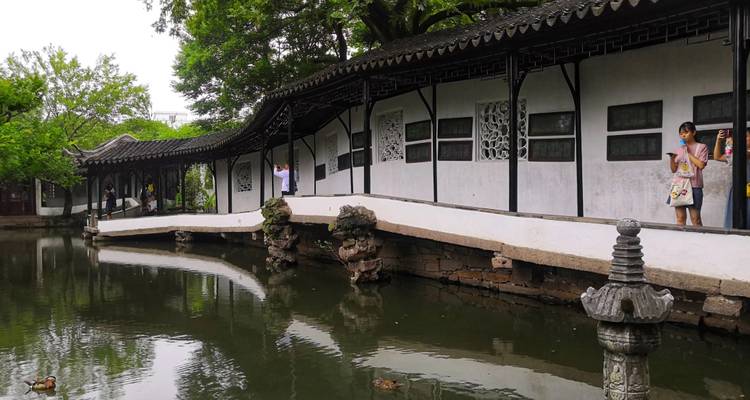Jardin chinois traditionnel avec un pont au-dessus d'un étang.