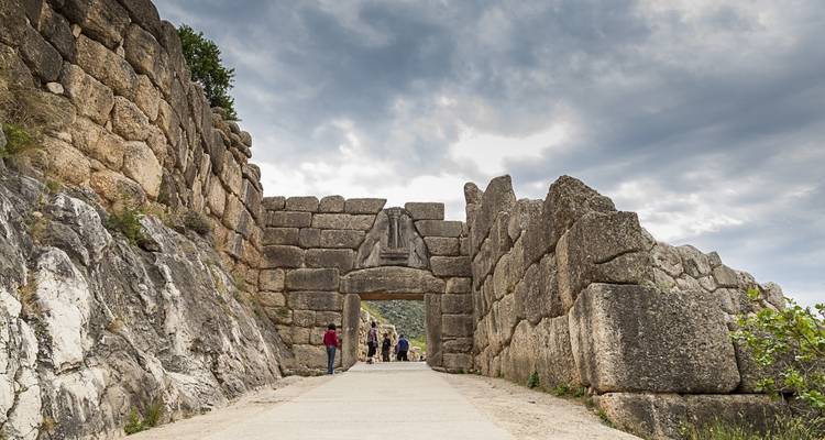 Visitors walk through the massive stone Lion Gate framed by imposing ancient walls.