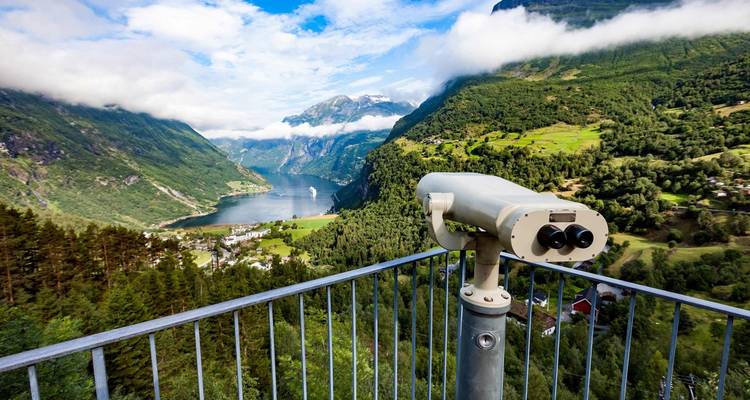 Schilderachtig uitzicht op een fjord met een telescoop op het platform met uitzicht over weelderige groene valleien en bergen.