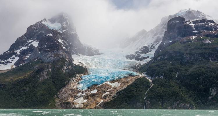 Des glaciers dévalant les montagnes vers des eaux turquoise.