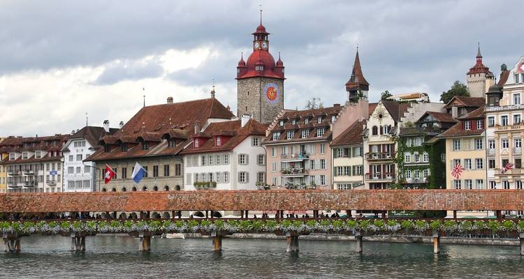 Architecture suisse traditionnelle au bord d'une rivière avec un clocher.