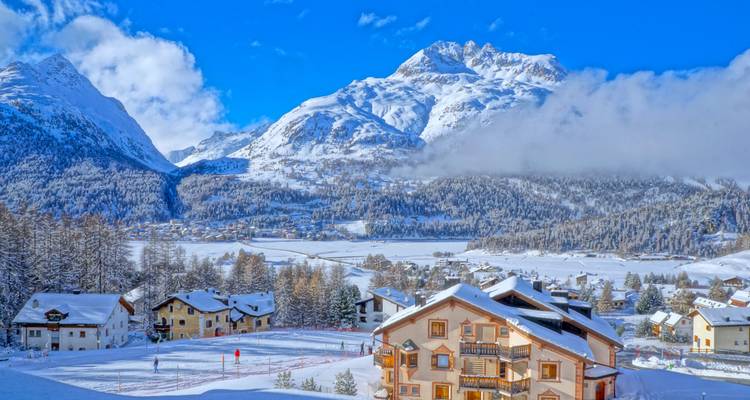 Ville de station d'hiver avec des montagnes enneigées.