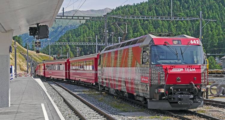 Train coloré à une gare de montagne.