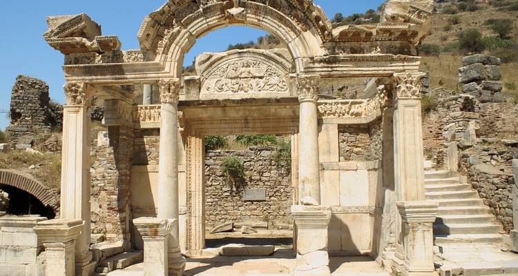 Oude stenen boog met ruïnes eromheen.