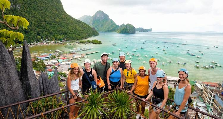 Grupo de pie en un mirador panorámico en un pueblo costero.