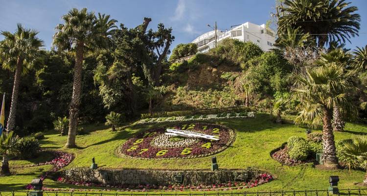 Un gran reloj floral ubicado en un paisaje exuberante.