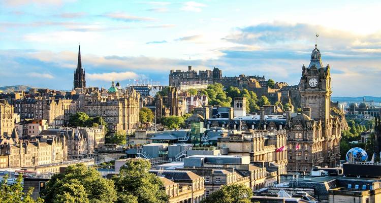 Skyline view of a city with historic architecture under a blue sky.