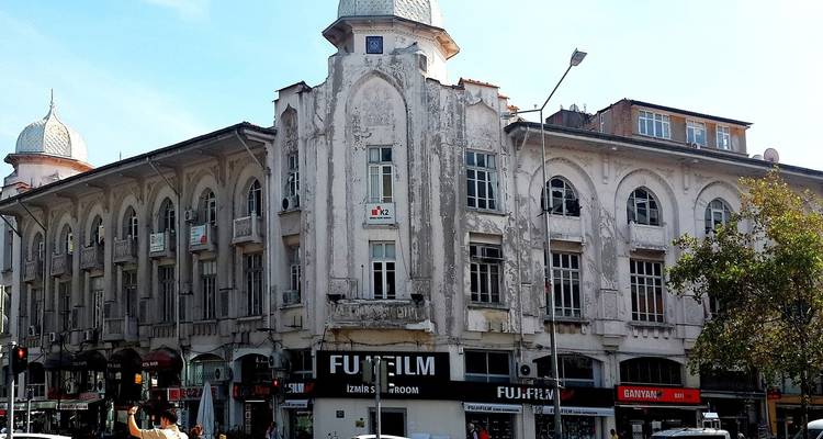 Oudere stedelijke architectuur met zichtbare winkelborden en een drukke straat.