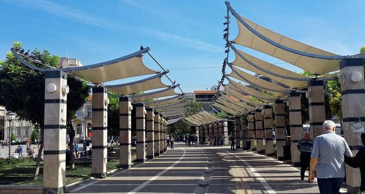Moderne stedelijke wandelweg met een overkapping en voetgangers.