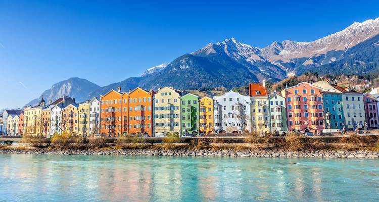 Colorful row of houses with a mountain backdrop.