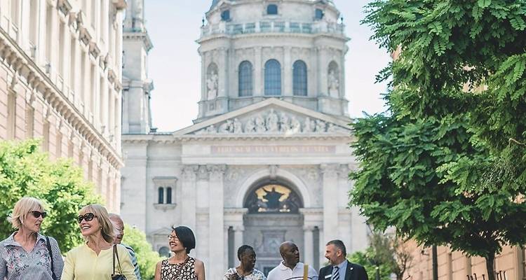 Groep mensen die voor een groot gebouw met koepel lopen