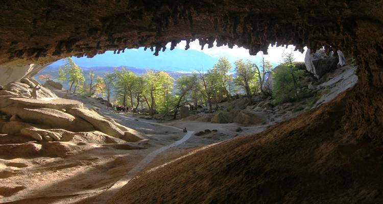 Blick aus einer Höhle heraus auf Bäume und Himmel.