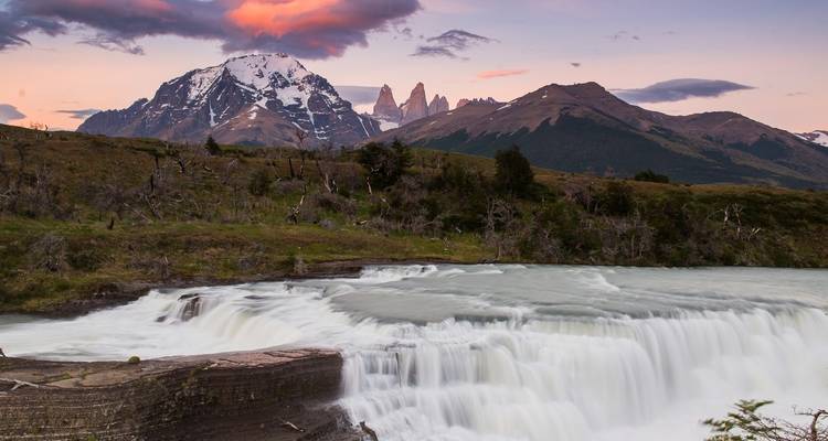 Wasserfall, der bei Sonnenuntergang mit Bergen herabstürzt.