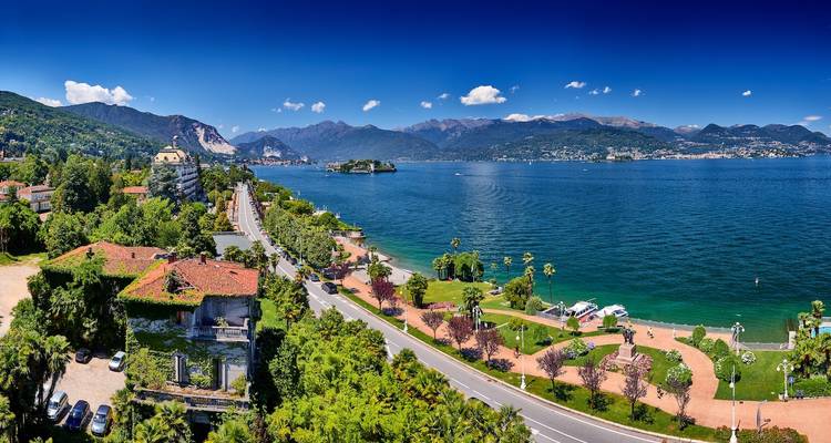 Scenic view of Lake Maggiore with mountains and buildings.