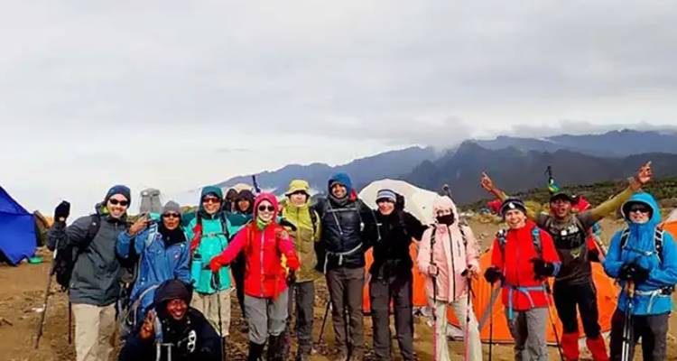 Un groupe de randonneurs posant dans un campement sur le mont Kilimandjaro.