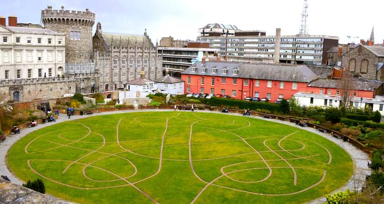 Stadtplatz mit historischen Gebäuden und einem Garten im Vordergrund.