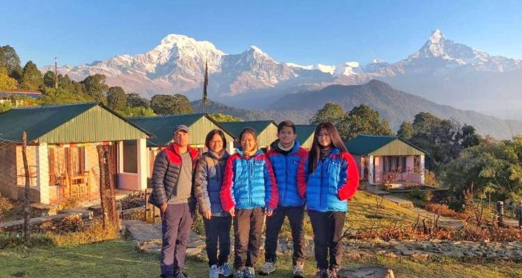 Famille posant avec un décor pittoresque de montagnes et de chalets