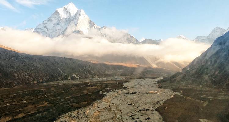 Scenic view of a valley with mist and mountain peaks

Translation: Vue panoramique d'une vallée avec brume et sommets montagneux