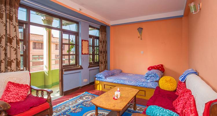 Homely living room with colorful cushions, rugs and plenty of natural light from balcony doors