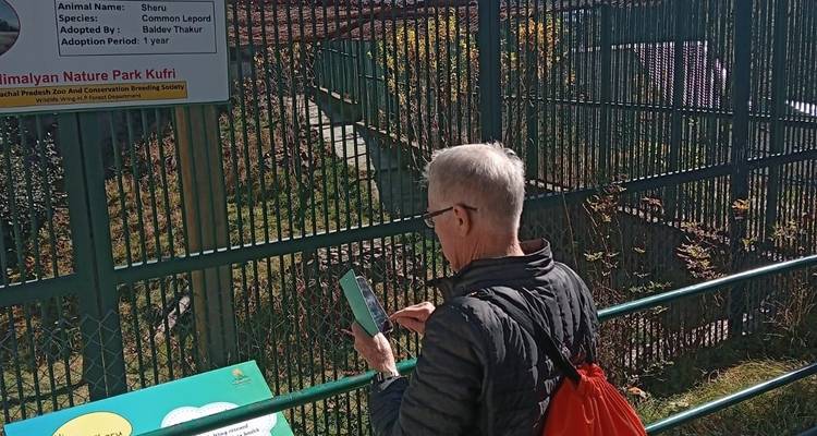 Älterer Mann liest ein Schild über eine Wildtierausstellung.