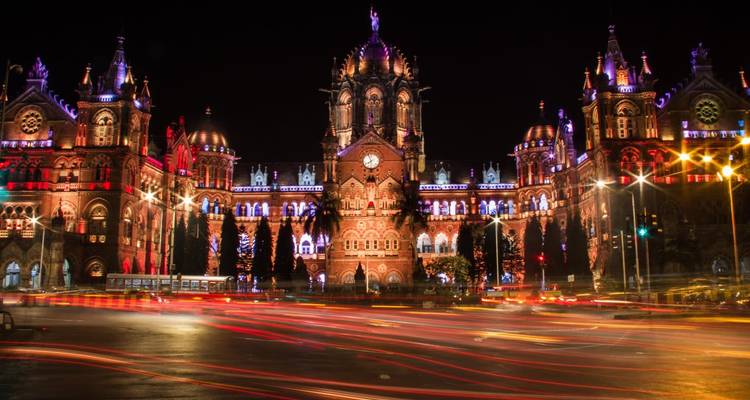 Beleuchtetes historisches Gebäude bei Nacht mit Lichtspuren.