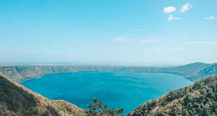 Vue aérienne d'un grand lac bleu entouré de collines.